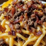 Loaded Bacon Cheeseburger Pasta – A Cheesy Comfort Food Favorite If you're craving something rich, cheesy, and full of flavor, this Loaded Bacon Cheeseburger Pasta is the ultimate comfort food. It’s packed with seasoned ground beef, crispy bacon, gooey cheese, and tender pasta—all the best parts of a classic bacon cheeseburger in a creamy, delicious pasta dish. Why You’ll Love This Recipe Cheesy and comforting – The perfect mix of gooey cheese and pasta. Packed with flavor – Bacon, beef, and seasonings make this dish irresistible. Quick and easy – Comes together in about 30 minutes. Family-friendly – A meal that both kids and adults will love. Ingredients Here’s a sneak peek at what you’ll need: Pasta (penne, rotini, or shells) Ground beef Bacon Onion Garlic Tomato sauce Worcestershire sauce Mustard Cheddar cheese Heavy cream Full list of ingredients and exact measurements are below. Directions 1. Cook the Pasta Boil your pasta in salted water until al dente. Drain and set aside. 2. Cook the Bacon In a large skillet, cook the bacon until crispy. Remove and drain on a paper towel-lined plate. 3. Brown the Beef Using the same skillet, cook the ground beef with onion and garlic until browned. Drain excess grease. 4. Build the Sauce Stir in tomato sauce, Worcestershire sauce, mustard, and seasonings. Let simmer for a few minutes. 5. Add the Cheese and Cream Lower the heat and stir in shredded cheddar and heavy cream until the sauce is smooth and cheesy. 6. Combine Everything Add the cooked pasta and crumbled bacon to the skillet, tossing to coat everything in the sauce. 7. Serve and Enjoy Top with extra cheese or fresh parsley before serving. Expert Tips and Tricks Use freshly shredded cheese – It melts better than pre-shredded. Don’t overcook the pasta – Keep it al dente so it holds up in the sauce. Crisp up the bacon well – Adds the perfect crunch to the dish. Recipe Variations and Possible Substitutions Swap ground beef for ground turkey for a lighter option. Add jalapeños or hot sauce for a spicy kick. Use different cheeses like Monterey Jack or Gouda for a unique flavor. Stir in some chopped pickles for extra burger-style tang. Serving and Pairing Suggestions This dish pairs well with a simple side salad, garlic bread, or roasted vegetables. A cold glass of iced tea or a classic soda makes a great drink choice! Storage and Reheating Tips Store leftovers in an airtight container in the fridge for up to 3 days. Reheat in a skillet over low heat with a splash of cream or milk to keep it creamy. Freeze for up to 2 months, thawing overnight before reheating. FAQs 1. Can I make this ahead of time? Yes! Prepare the dish and store it in the fridge. Reheat before serving. 2. Can I use a different type of pasta? Absolutely! Any short pasta shape works well. 3. How do I make this dish even cheesier? Add more shredded cheese or a little cream cheese for extra richness. 4. Can I make this dish spicy? Yes! Add crushed red pepper flakes or diced jalapeños for some heat. Conclusion Loaded Bacon Cheeseburger Pasta is a delicious mashup of two comfort food favorites. Whether you're cooking for family dinner or meal prepping for the week, this cheesy, satisfying dish is sure to be a hit!